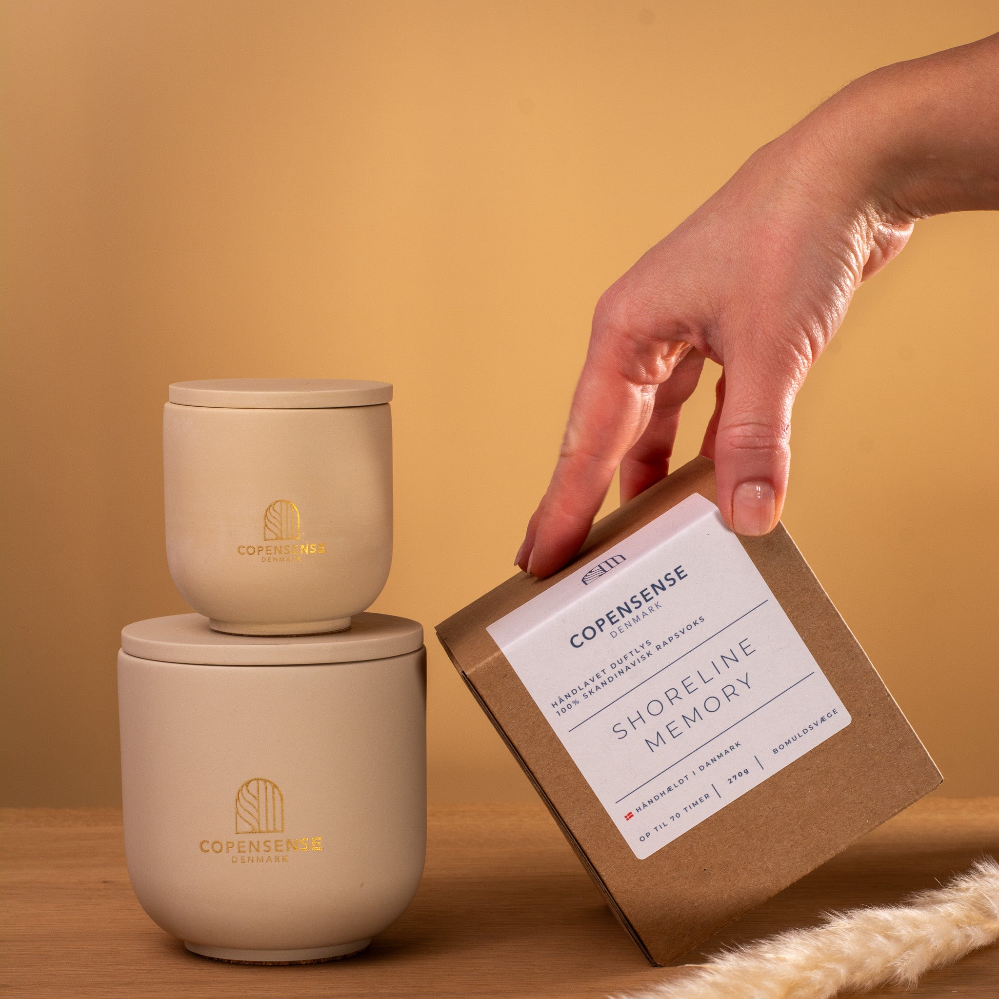 Beige candle set with Copensense branding Shoreline Memory candle next to large 270g jar and packaging box on wood surface.