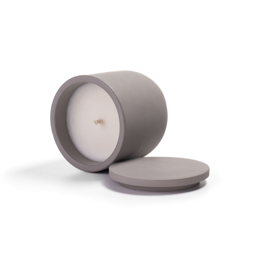 Candle in a gray container with lid on a white background