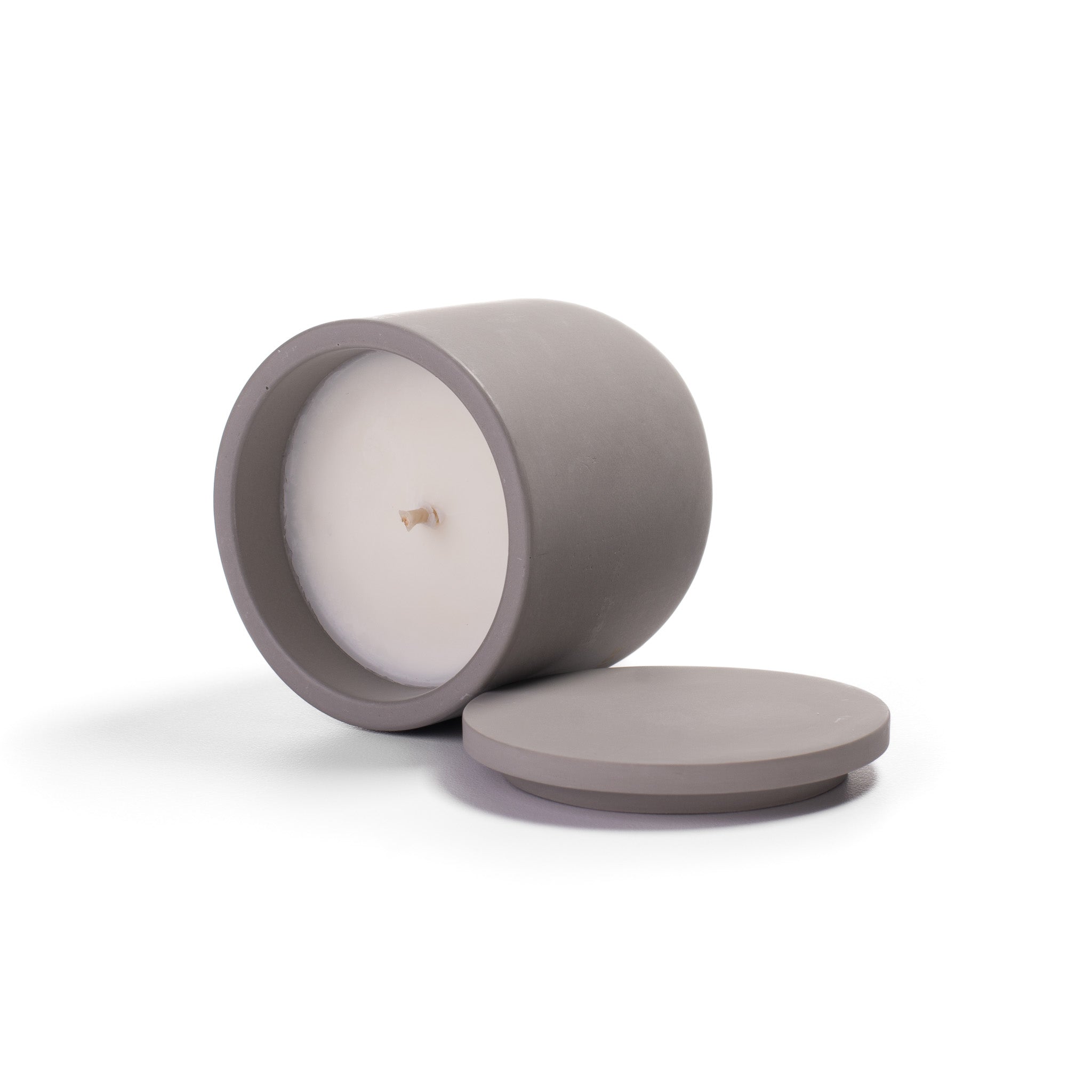 Candle in a gray container with lid on a white background